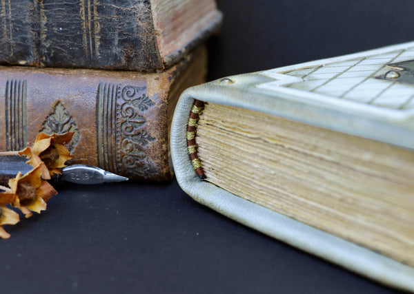 Small leather journal with brass etching of Jesus Christ, white leather with gold tooled decoration, tea stained pages